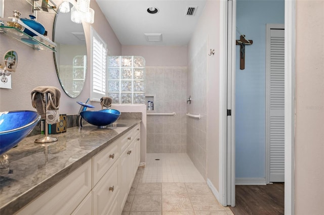 bathroom featuring vanity, tile patterned floors, and tiled shower