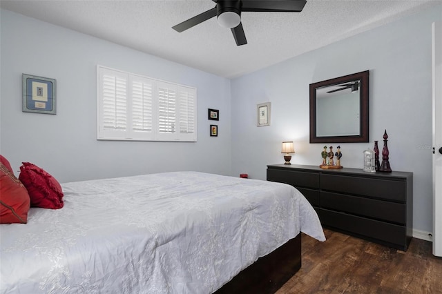 bedroom featuring dark wood-type flooring, ceiling fan, and a textured ceiling