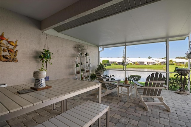 sunroom / solarium with a water view and lofted ceiling with beams