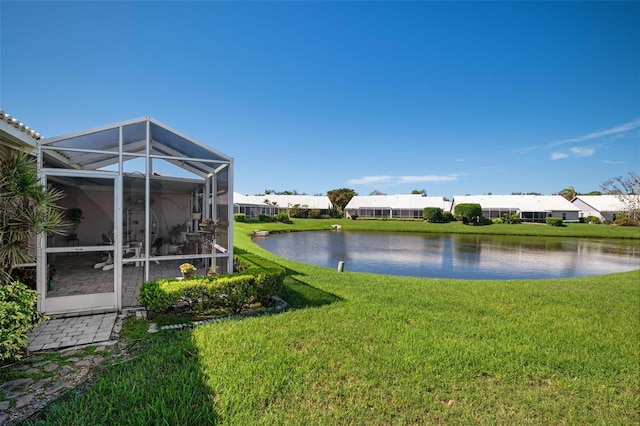 view of yard with a water view and glass enclosure