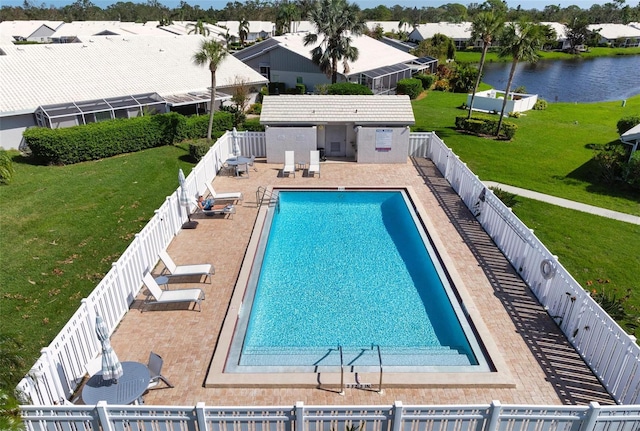 view of pool featuring a water view, a patio, a lawn, and an outdoor structure