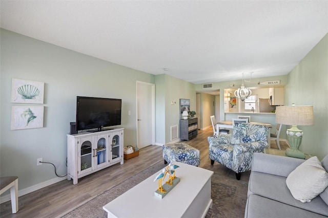 living room featuring a notable chandelier and hardwood / wood-style floors