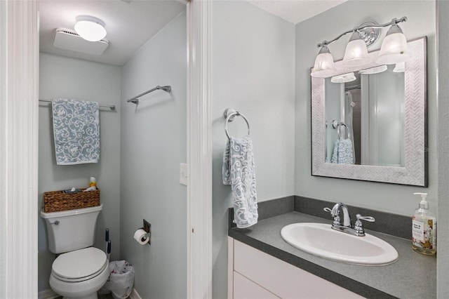 bathroom featuring an inviting chandelier, vanity, and toilet