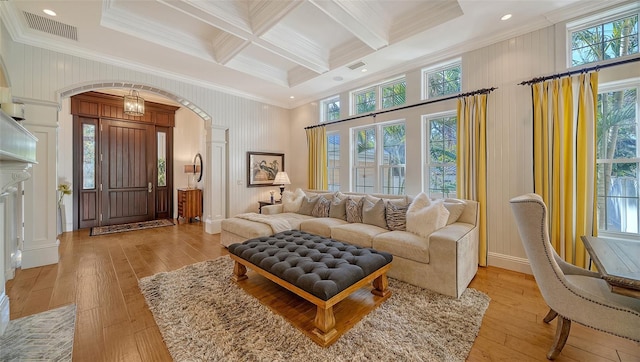 living room with beam ceiling, crown molding, coffered ceiling, and light wood-type flooring