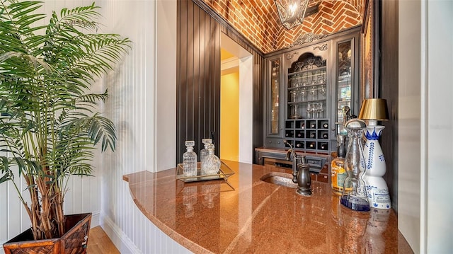 bar featuring brick ceiling, sink, and lofted ceiling