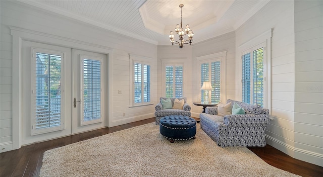 living area featuring french doors, dark hardwood / wood-style floors, and a notable chandelier