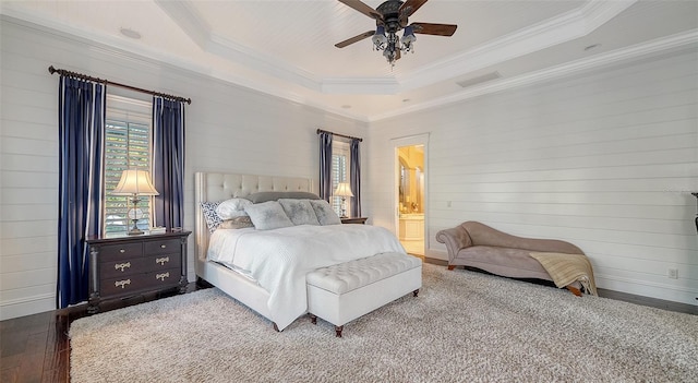 bedroom featuring a raised ceiling, ceiling fan, crown molding, hardwood / wood-style floors, and connected bathroom