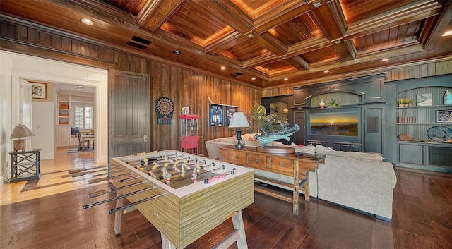 living room with wooden ceiling, coffered ceiling, beamed ceiling, crown molding, and wood walls