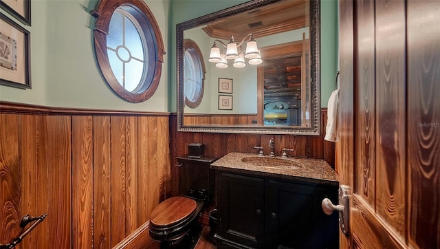 bathroom featuring vanity, crown molding, and wooden walls