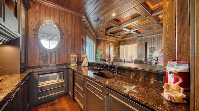 interior space with coffered ceiling, stainless steel microwave, wooden walls, and wood ceiling