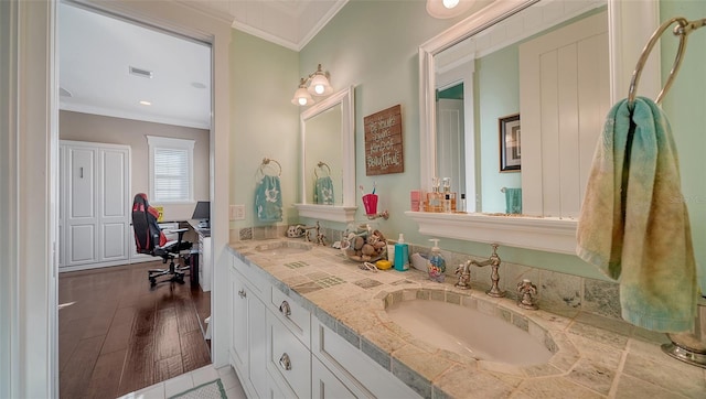 bathroom featuring hardwood / wood-style floors, vanity, and crown molding