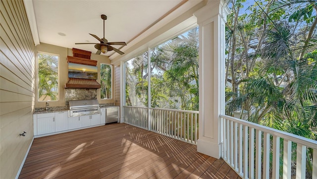 unfurnished sunroom featuring ceiling fan and sink