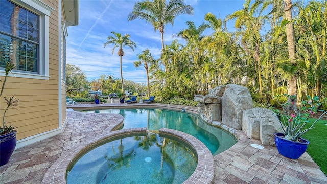 view of swimming pool featuring an in ground hot tub