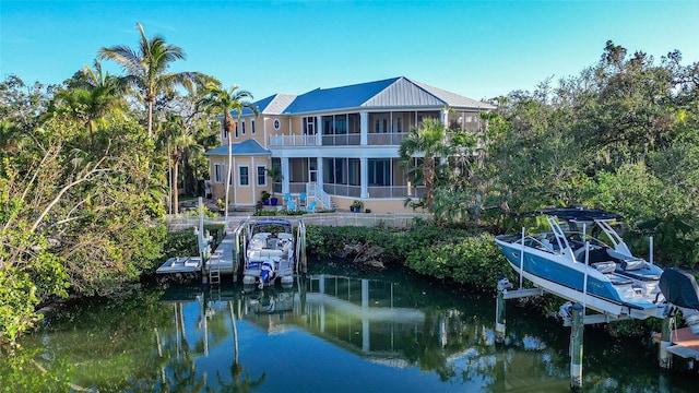 rear view of property with a water view and a sunroom