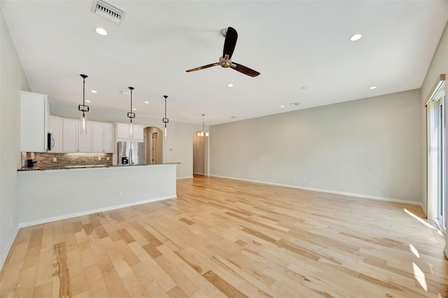 unfurnished living room with ceiling fan and light hardwood / wood-style flooring