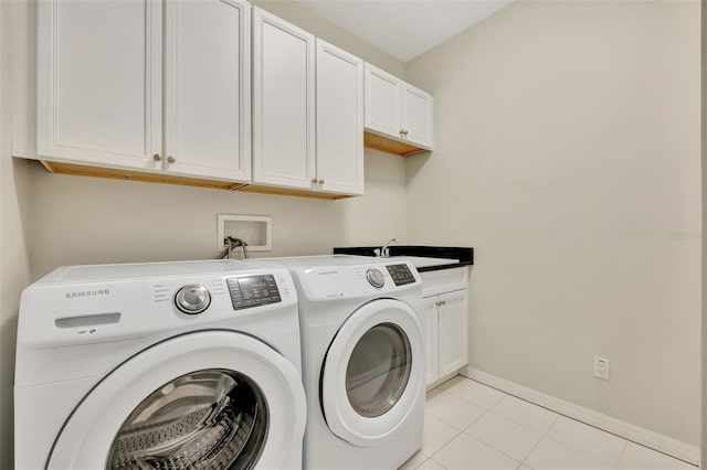 washroom with sink, light tile patterned floors, cabinets, and separate washer and dryer