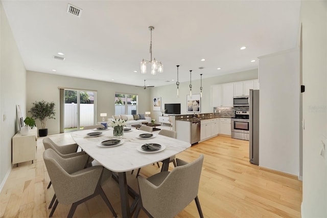 dining room featuring a notable chandelier and light hardwood / wood-style floors