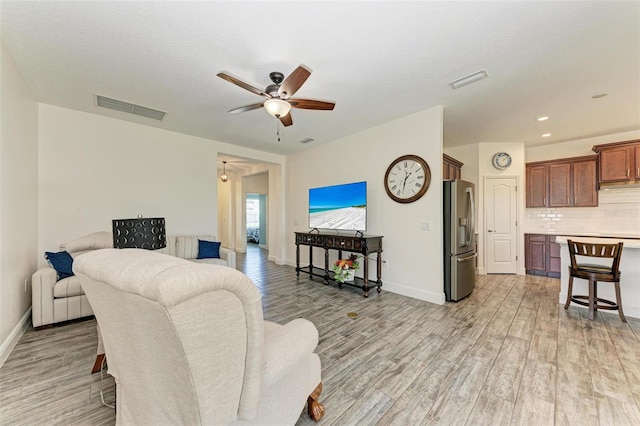 living room with light wood-type flooring and ceiling fan