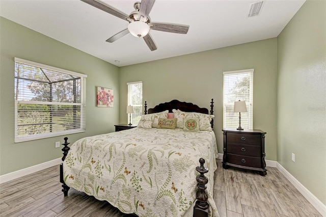 bedroom featuring light hardwood / wood-style floors, multiple windows, and ceiling fan