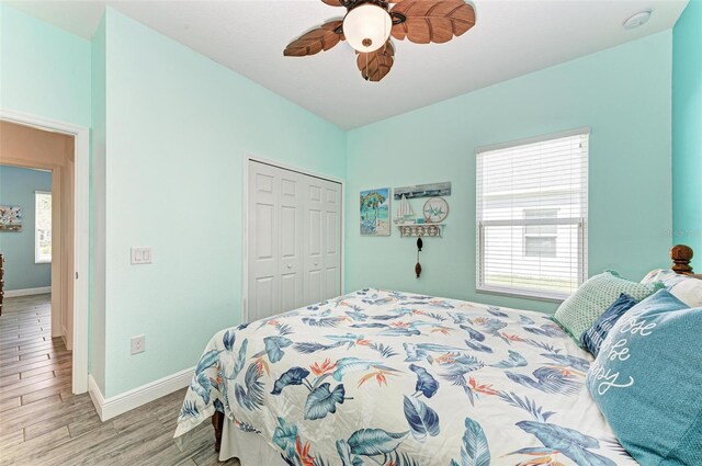 bedroom featuring a closet, light wood-type flooring, and ceiling fan