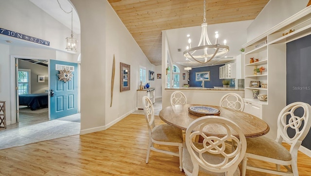 dining area with light hardwood / wood-style floors, an inviting chandelier, high vaulted ceiling, and wooden ceiling