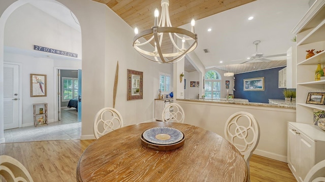 dining space with high vaulted ceiling, ceiling fan with notable chandelier, light wood-type flooring, and wooden ceiling