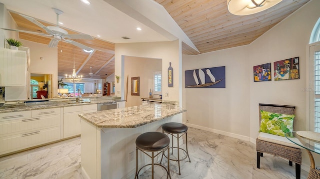 kitchen featuring light stone countertops, wooden ceiling, a breakfast bar area, and kitchen peninsula