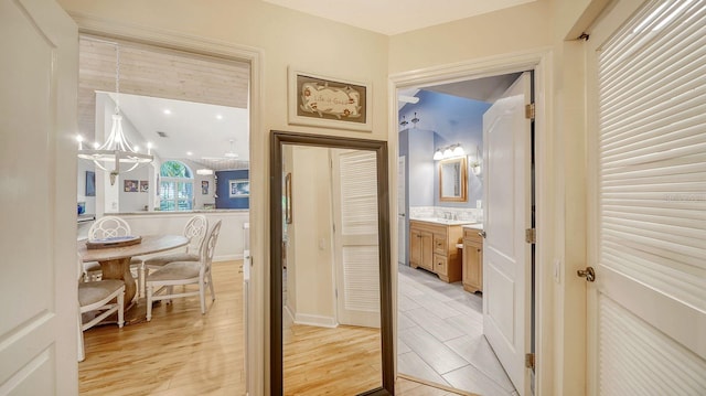 corridor with a chandelier and light hardwood / wood-style floors