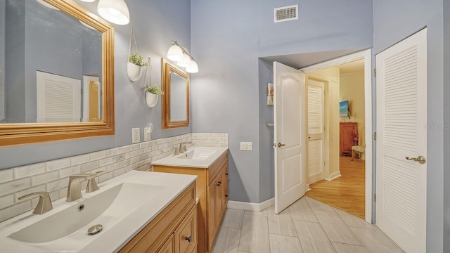 bathroom featuring vanity, decorative backsplash, and hardwood / wood-style flooring