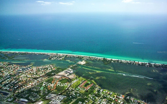 birds eye view of property featuring a water view and a beach view