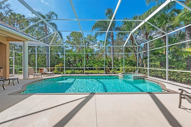 view of pool with a patio area, an in ground hot tub, and glass enclosure