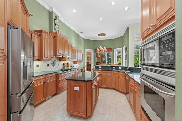 kitchen featuring a center island, hanging light fixtures, light tile patterned floors, appliances with stainless steel finishes, and a notable chandelier