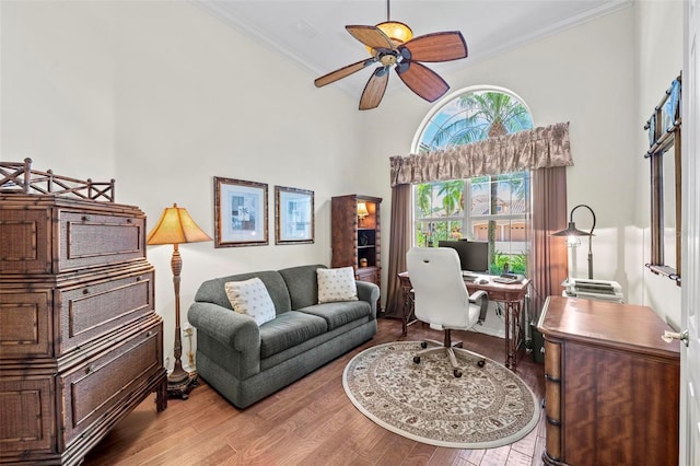 office area with ceiling fan, light hardwood / wood-style flooring, a high ceiling, and ornamental molding