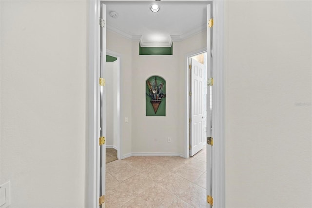 hall with ornamental molding and light tile patterned flooring