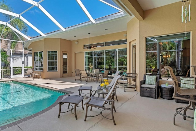 view of swimming pool featuring a patio area, ceiling fan, and glass enclosure