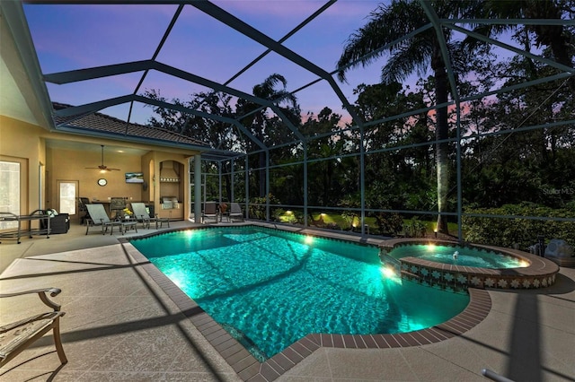 pool at dusk with a lanai, ceiling fan, a patio, and an in ground hot tub