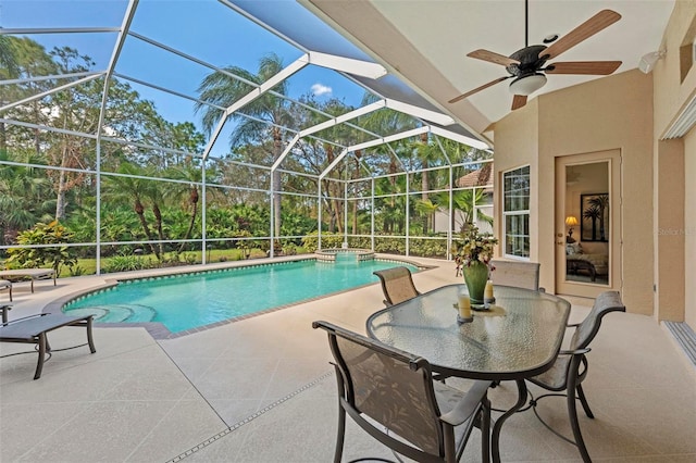 view of pool with glass enclosure, ceiling fan, and a patio area