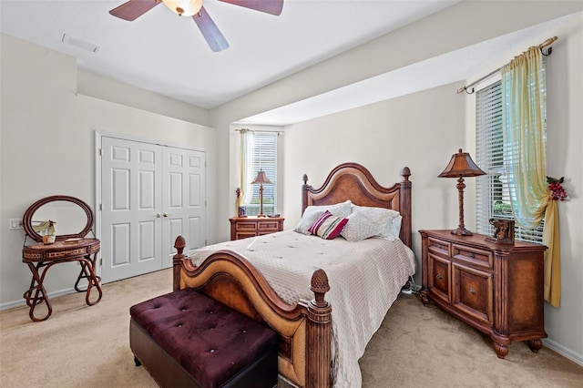 carpeted bedroom featuring ceiling fan, a closet, and multiple windows