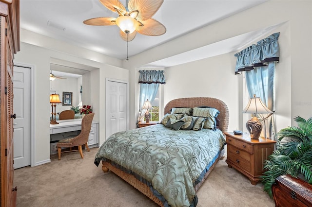 bedroom with ceiling fan, a closet, built in desk, and light carpet