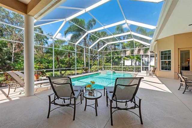 view of swimming pool with glass enclosure and a patio area