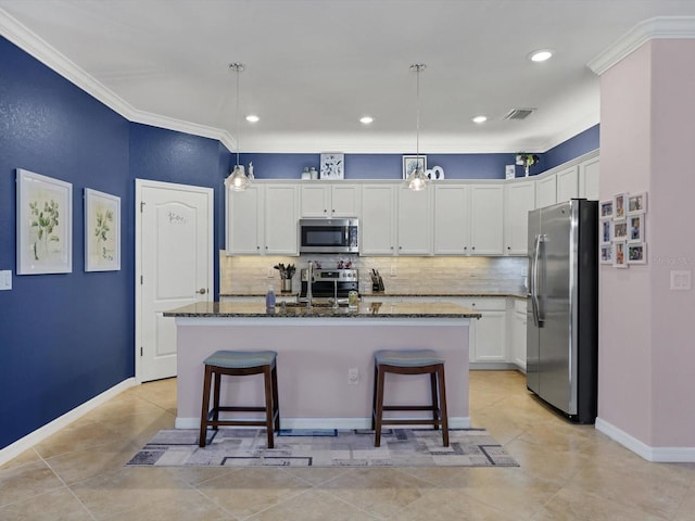 kitchen featuring a center island with sink, a breakfast bar, and appliances with stainless steel finishes