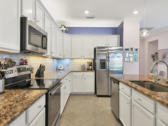 kitchen with white cabinets, hanging light fixtures, dark stone countertops, sink, and stainless steel appliances