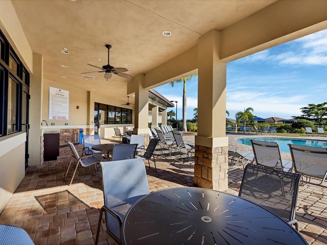 view of patio featuring a community pool and ceiling fan