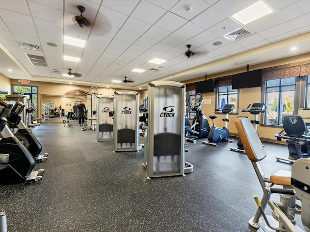 workout area featuring ceiling fan, a paneled ceiling, and plenty of natural light