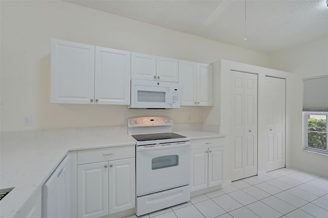 4210 Caddie Dr E Unit 102, Bradenton, FL 34203 - kitchen with white cabinets, light tile patterned floors, and white appliances