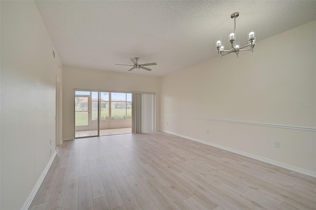 4210 Caddie Dr E Unit 102, Bradenton, FL 34203 - spare room featuring baseboards, light wood-style floors, a textured ceiling, and ceiling fan with notable chandelier