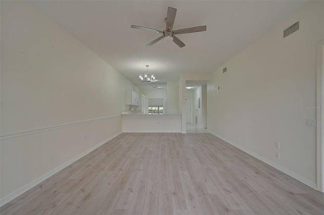 unfurnished living room with ceiling fan with notable chandelier and light hardwood / wood-style floors