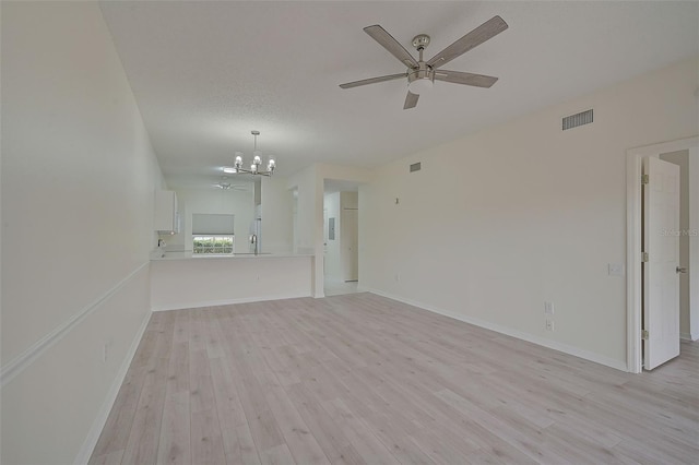 unfurnished living room featuring light hardwood / wood-style floors, a textured ceiling, and ceiling fan with notable chandelier