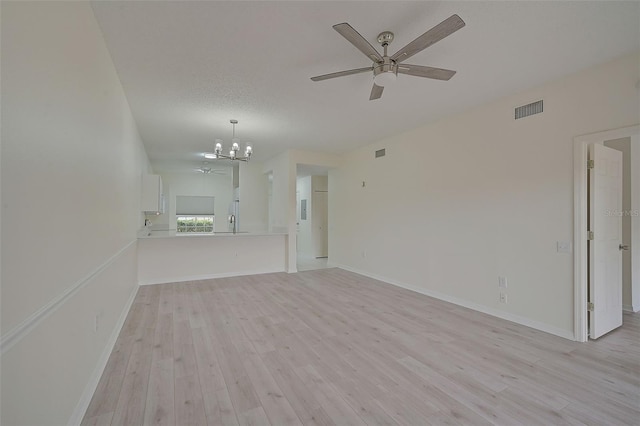 4210 Caddie Dr E Unit 102, Bradenton, FL 34203 - unfurnished living room with baseboards, light wood-style flooring, visible vents, and ceiling fan with notable chandelier