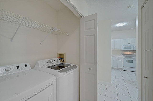 4210 Caddie Dr E Unit 102, Bradenton, FL 34203 - laundry room with light tile patterned floors, laundry area, and washing machine and dryer